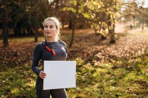 fille sportive tenant une feuille blanche à l'extérieur photo