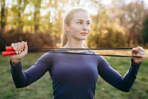 entraînement dans le parc, fille tenant une corde à sauter. photo