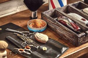 coiffeur outils sur en bois Contexte. Haut vue sur en bois table avec ciseaux, peigne, brosses à cheveux et pinces à cheveux, tondeuse. photo