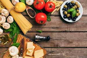 italien nourriture tomates à cuire, basilic, Pâtes, olive pétrole et fromage sur en bois arrière-plan, Haut voir, copie espace. photo