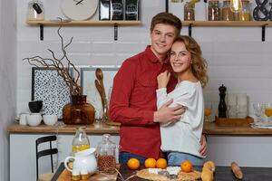 content Jeune charmant couple sur cuisine étreindre chaque autre. elles ou ils prendre plaisir dépenses temps togehter photo