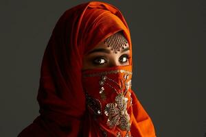 studio coup de une Jeune charmant femme portant le terre cuite hijab décoré avec paillettes et bijoux. arabe style. photo