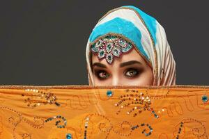 studio coup de une chromage femelle portant le coloré hijab décoré avec paillettes et bijoux. arabe style. photo