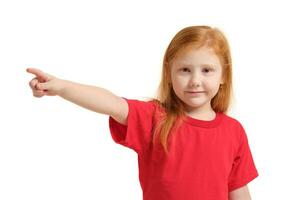 éducation, école et imaginaire écran concept - mignonne peu fille montrer du doigt dans le air ou imaginaire écran photo