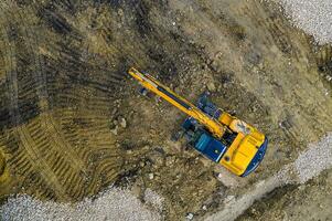 étourdissant aérien vue de le arrêté Jaune excavatrice à une construction site photo