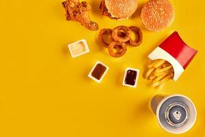 vite nourriture plat Haut voir. français frites, Hamburger, Mayonnaise et ketchup sauces sur Jaune Contexte. photo