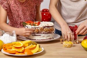 peu copains sont fabrication une gâteau ensemble à une cuisine contre une blanc mur avec étagères sur il. photo