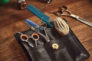 coiffeur outils sur en bois Contexte. Haut vue sur en bois table avec ciseaux, peigne, brosses à cheveux et pinces à cheveux, tondeuse. photo