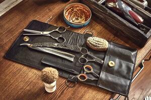 coiffeur outils sur en bois Contexte. Haut vue sur en bois table avec ciseaux, peigne, brosses à cheveux et pinces à cheveux, tondeuse. photo