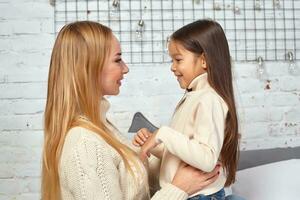 magnifique Jeune femme et sa charmant peu fille sont étreindre. photo