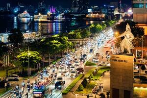 ho chi minh ville, vietnam - SEP 2, 2023 vue de moi ligne rond point avec lourd circulation près Bach dang bateau-bus station Port et saigon rivière à bleu heure photo