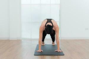 magnifique Jeune femme pratiquant yoga à maison. yoga asana. photo