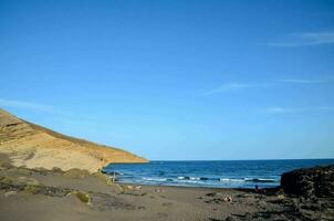 une plage avec une falaise et une bleu ciel photo