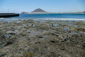 le plage et rochers sont couvert dans boue et l'eau photo