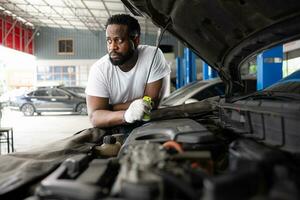 tous les deux de professionnel auto mécanicien travail ensemble dans auto réparation magasin. photo