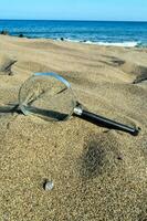 une grossissant verre sur le plage photo