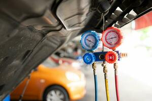 voiture mécanicien travail dans auto réparation boutique, inspecter le opération de le voitures air Conditionneur et réfrigérant. photo