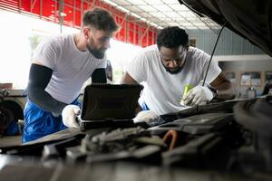 tous les deux de professionnel auto mécanicien travail ensemble dans auto réparation magasin. photo