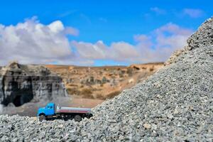 une bleu un camion est garé sur Haut de une pile de gravier photo