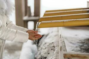 touristique la lessive mains dans Hokkaido Jingu tombeau avec neige dans hiver saison, Japonais bouddhisme shinto temple. point de repère et populaire pour attractions dans hokkaïdo, Japon. Voyage et vacances concepts photo
