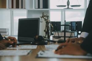 consultation et conférence d'avocats masculins et de femmes d'affaires professionnelles travaillant et discutant dans un cabinet d'avocats en fonction. notions de droit, marteau de juge avec balance de justice. photo