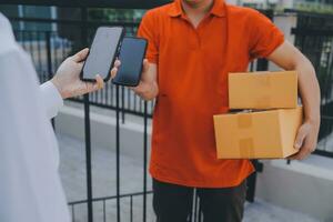 asiatique femme recevoir produit de livraison homme à maison, Jeune propriétaire femme commande produit de téléphone intelligent application, femme avec en ligne affaires ou pme concept. photo