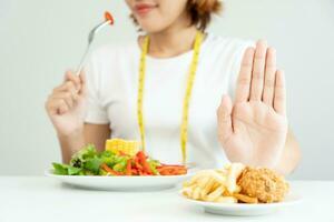 beauté svelte femelle corps embrouiller français frites et frit poulet. femme dans restaurant atteint poids perte objectif pour en bonne santé vie, fou à propos minceur, mince taille, nutritionniste. régime, corps forme. photo