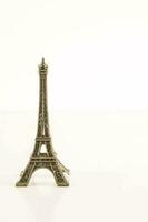 une petit métal Eiffel la tour sur une blanc Contexte photo