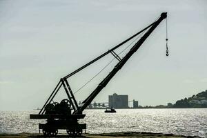 une grue est levage une bateau sur le l'eau photo