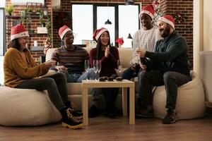 entreprise collègues profiter Nouveau année fête dans de fête décoré bureau. excité diverse Hommes et femmes collègues de travail ouverture pétillant du vin bouteille à Noël entreprise fête photo