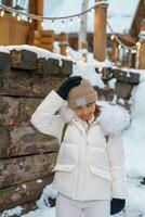 femme touristique visite dans furano, voyageur dans chandail tourisme ninglé terrasse chalets avec neige dans l'hiver. point de repère et populaire pour attractions dans hokkaïdo, Japon. Voyage et vacances concept photo