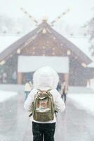 femme touristique visite dans sapporo, voyageur dans chandail à la recherche Hokkaido tombeau avec neige dans hiver saison. point de repère et populaire pour attractions dans hokkaïdo, Japon. Voyage et vacances concept photo