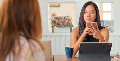 jeune cadre féminin avec un smartphone écoutant l'équipe pour présenter son travail sérieusement. photo