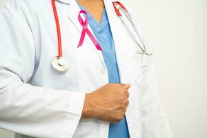 cancer du sein, femme médecin asiatique avec ruban rose, symbole de la journée mondiale du cancer du sein. photo