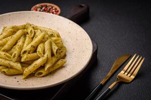 délicieux Frais Pâtes Penne avec vert Pesto sauce avec basilic, sel et épices photo