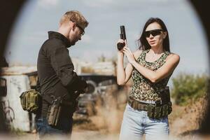 une fille apprend à tirer une pistolet à une tournage intervalle avec un instructeur photo