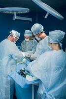 une très qualifié équipe de chirurgiens effectue une complexe opération à retirer une pancréatique kyste en utilisant médical instruments photo