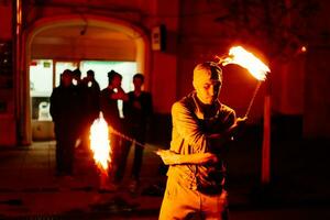 le gars sur le rue effectue avec Feu torches photo