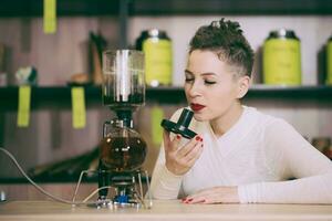 le fille est fabrication thé dans une café photo