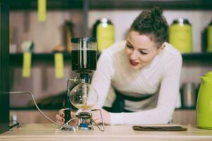 le fille est fabrication thé dans une café photo