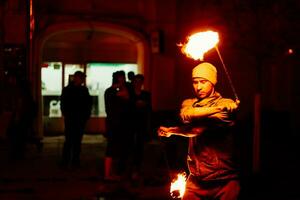 le gars sur le rue effectue avec Feu torches photo