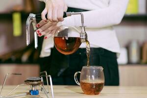 le fille est fabrication thé dans une café photo