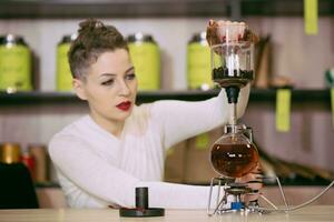 le fille est fabrication thé dans une café photo