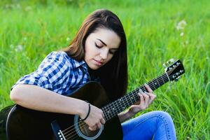 fille sur une vert Prairie en jouant guitare photo