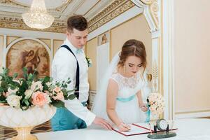 magnifique la mariée et jeune marié Signature dans le enregistrement Bureau photo