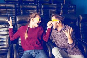 gars et fille 3d des lunettes sont très inquiet tandis que en train de regarder une film dans une cinéma photo