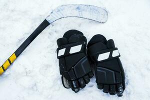 le gants et le hockey bâton allonger sur le neige photo