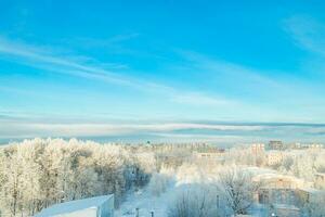 vue sur la ville en hiver. maisons et arbres dans la neige. début de la saison d'hiver. photo