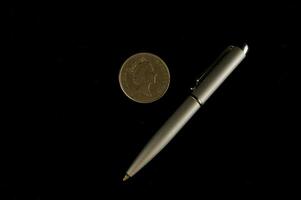 une argent stylo et une penny sur une noir Contexte photo