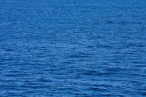 le océan est bleu et calme avec une peu bateaux photo